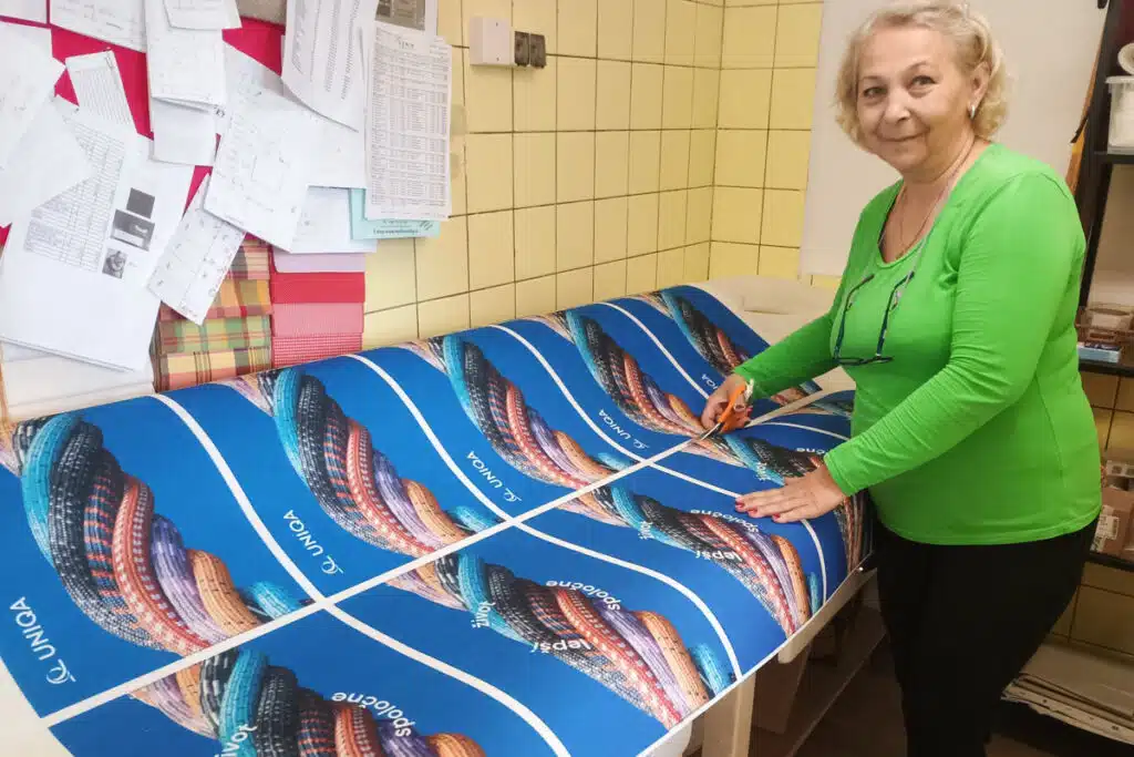 Výrobky FOREWEAR pro Uniqa stříhá švadlena v šicí dílně